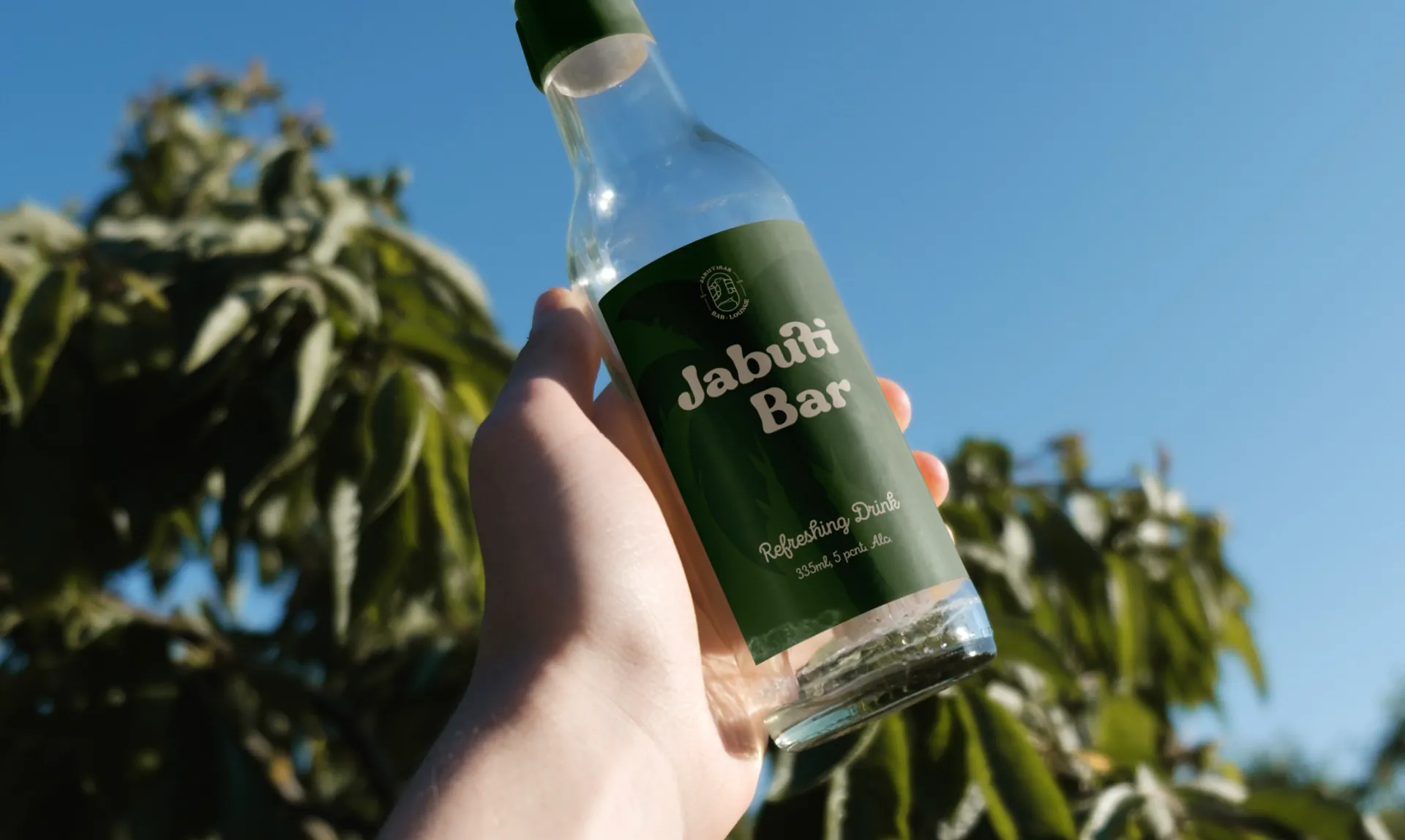 Bottle with a green JabutiBar label against the sky