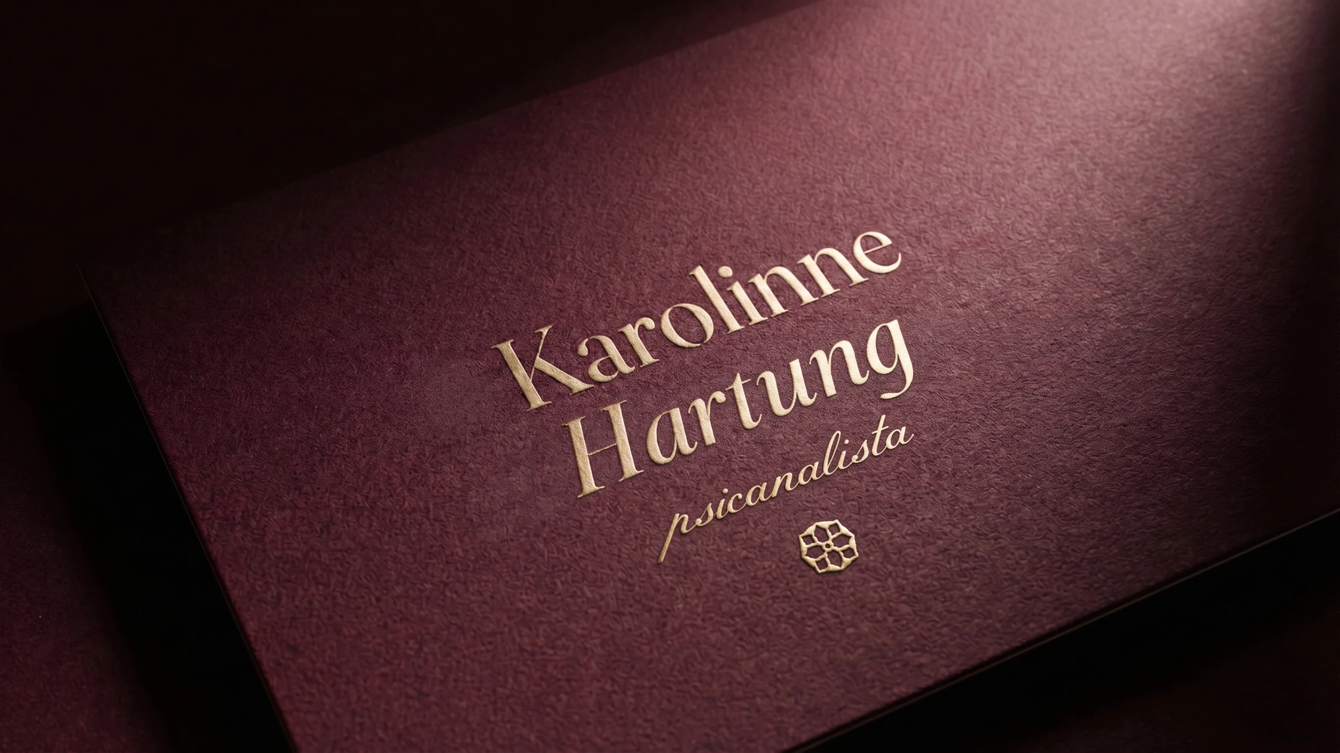Karolinne Hartung logotype in gold relief on textured bordeaux paper