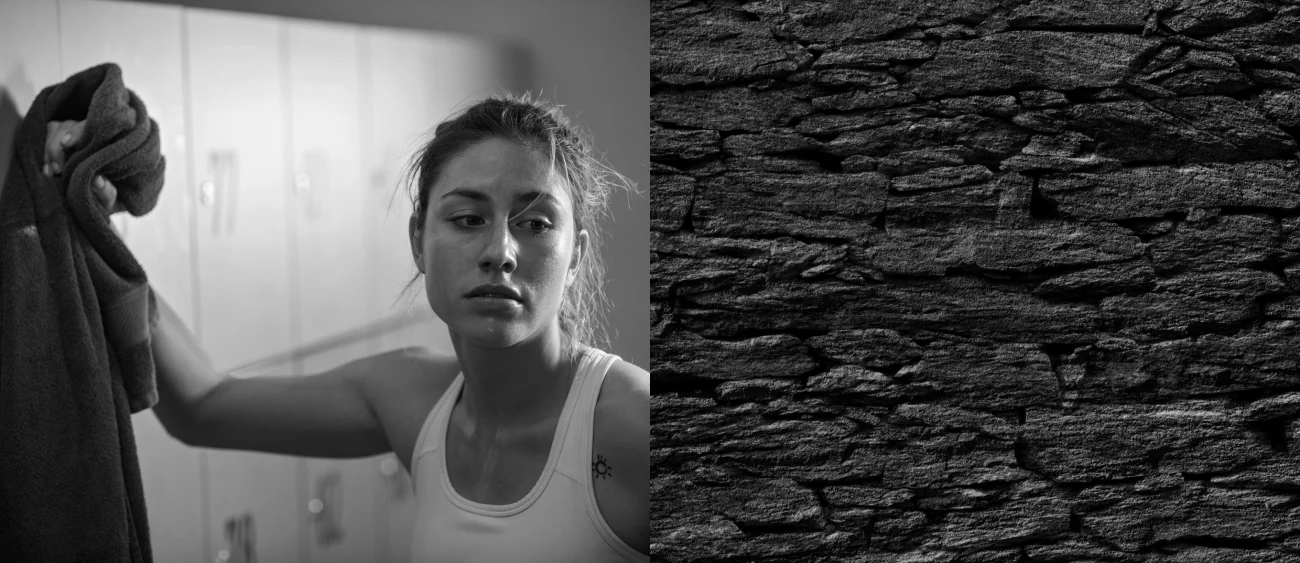 Black-and-white portrait of an athlete with a towel in a locker room, next to a dark stone texture